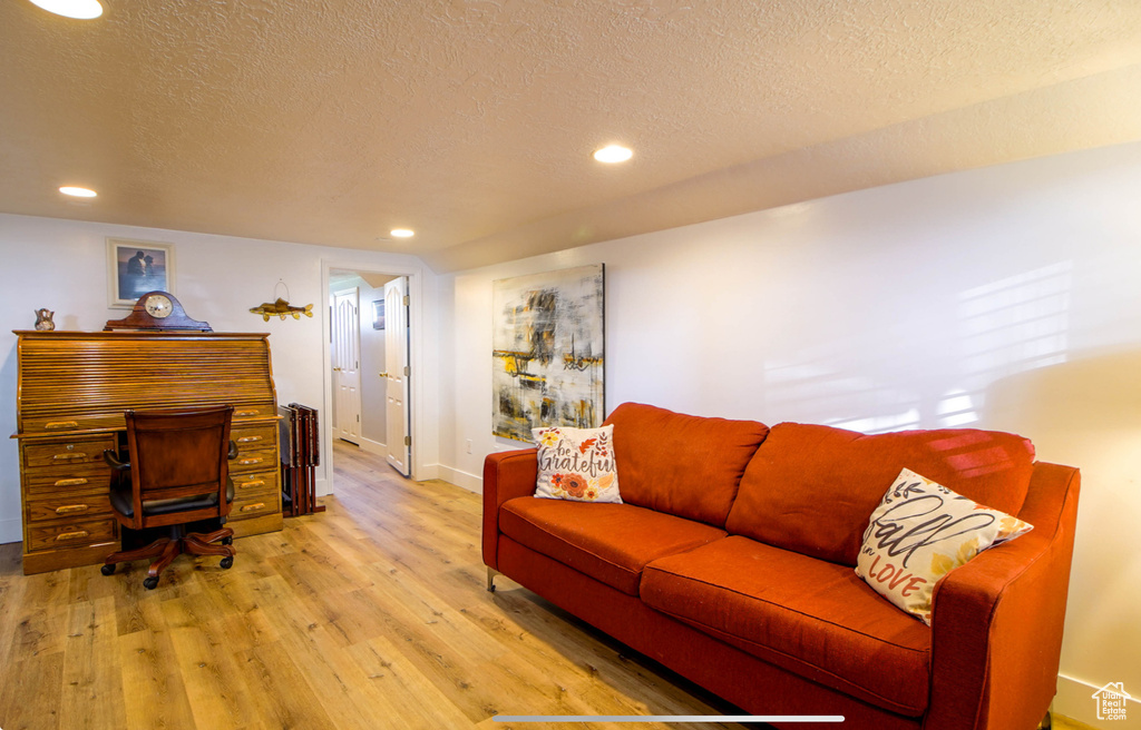 Living area featuring a textured ceiling, light wood-style flooring, recessed lighting, and baseboards