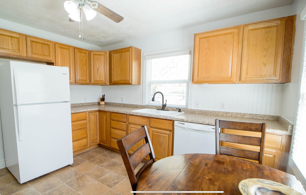 Kitchen featuring white appliances, a sink, light countertops, and ceiling fan