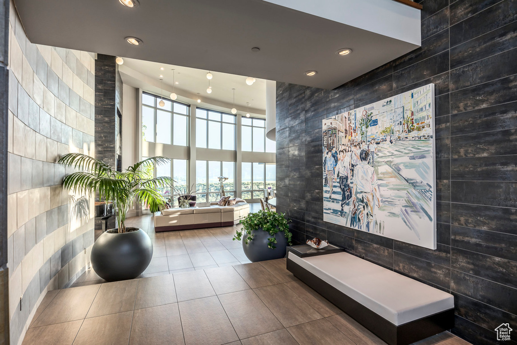 Building lobby with recessed lighting, a towering ceiling, and tile walls