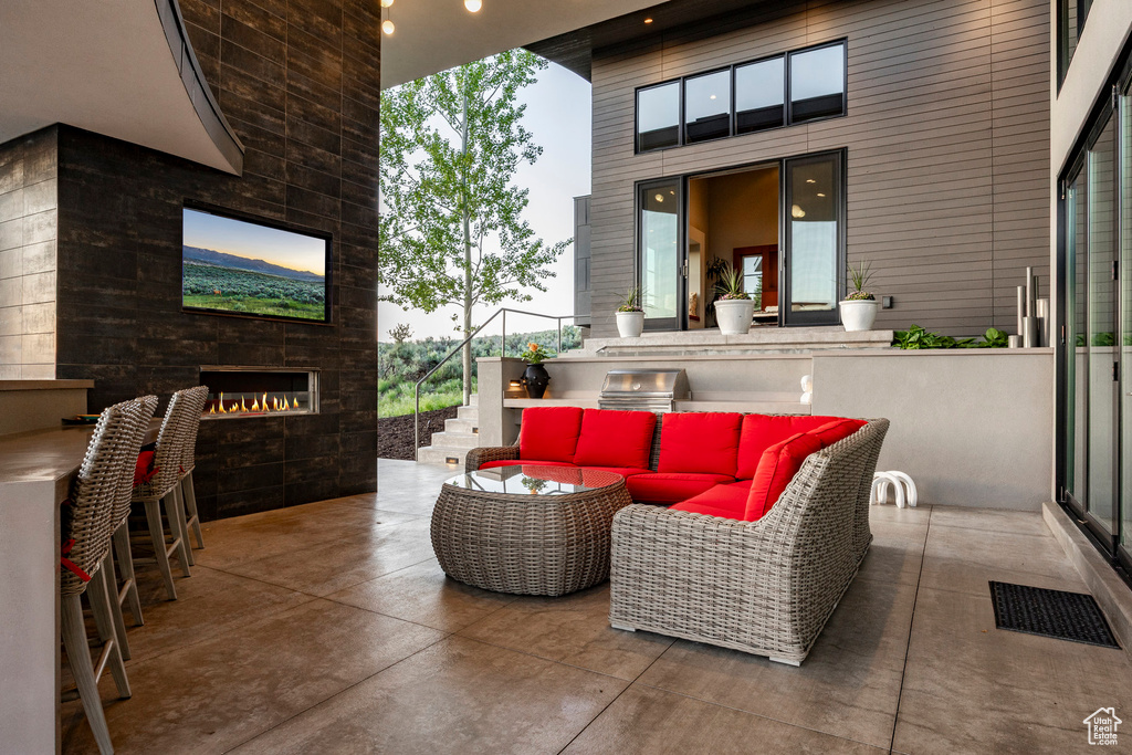 View of patio / terrace with an outdoor living space with a fireplace, a bar, and stairway
