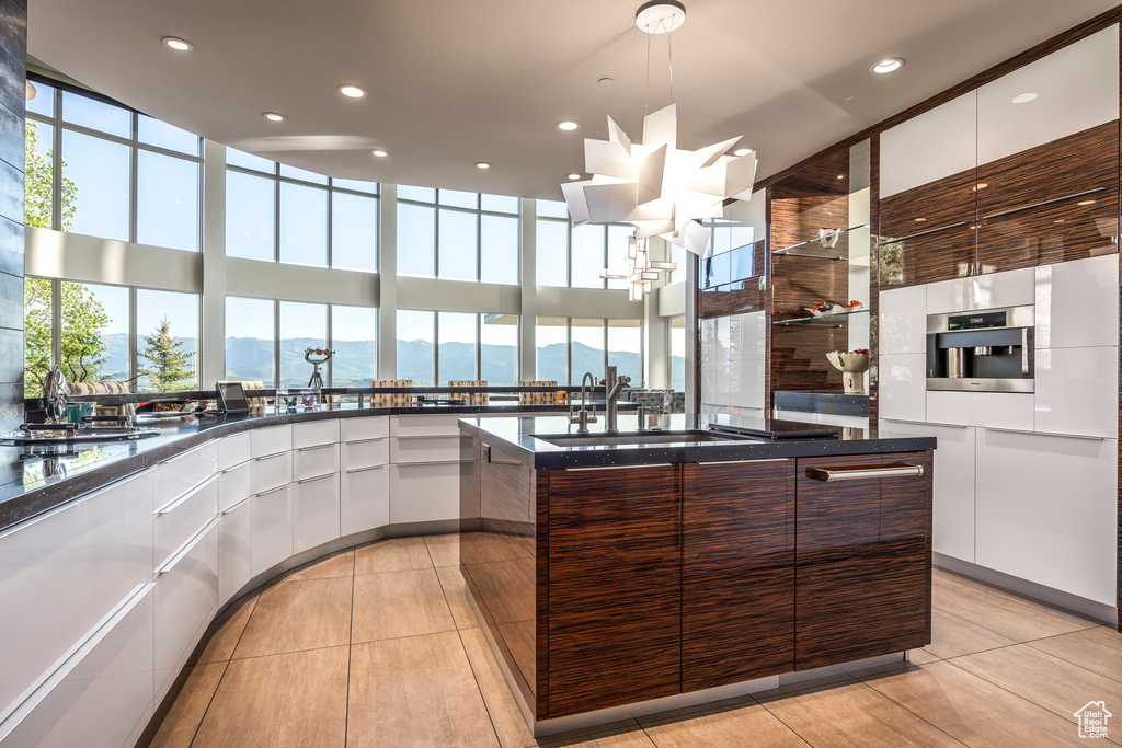 Kitchen featuring modern cabinets, white cabinets, healthy amount of natural light, a sink, and recessed lighting