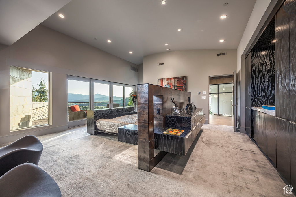 Carpeted living room with high vaulted ceiling, recessed lighting, and a mountain view