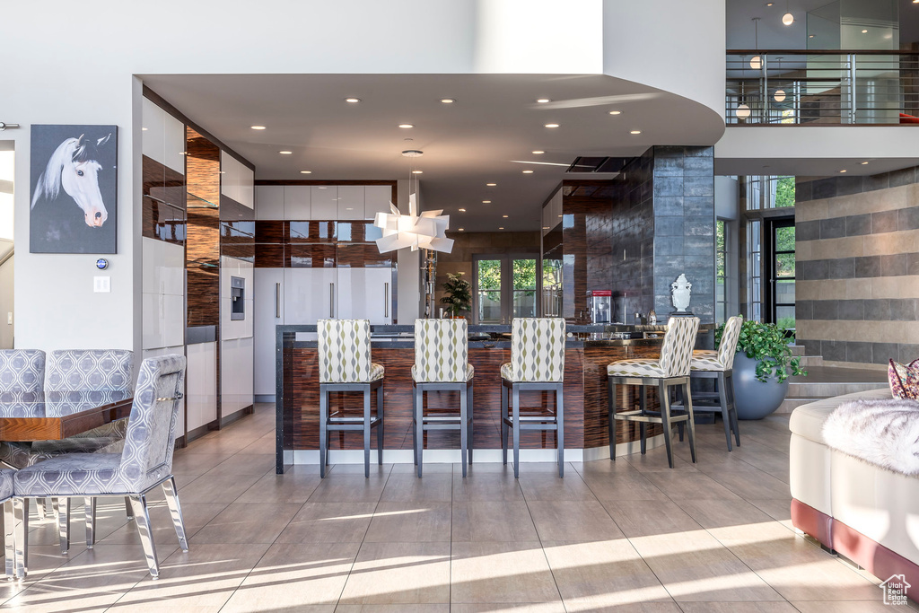 Kitchen with healthy amount of natural light, tile patterned floors, recessed lighting, and a towering ceiling