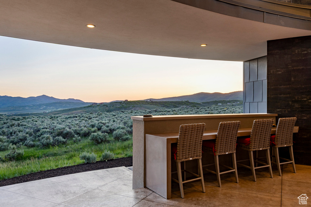Patio terrace at dusk featuring a mountain view and a patio