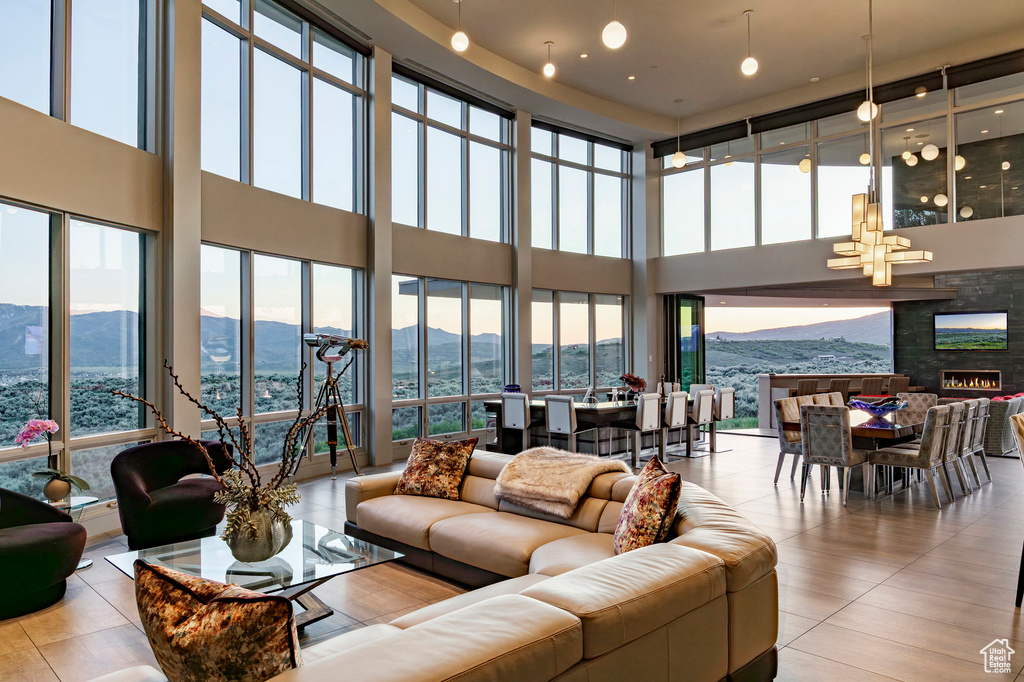 Living room with a towering ceiling, a mountain view, healthy amount of natural light, and a chandelier