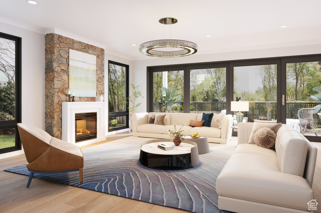 Living room with ornamental molding, wood finished floors, a fireplace, and recessed lighting