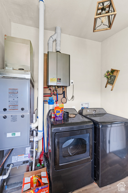 Laundry area with water heater and washer and clothes dryer