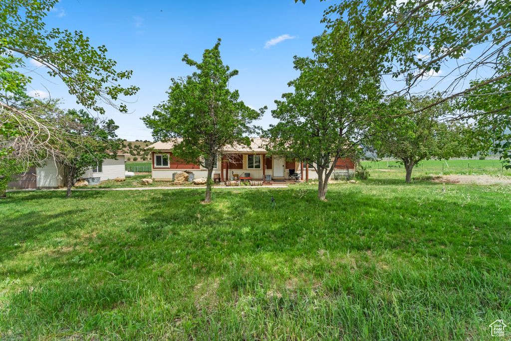 View of grassy yard featuring a porch
