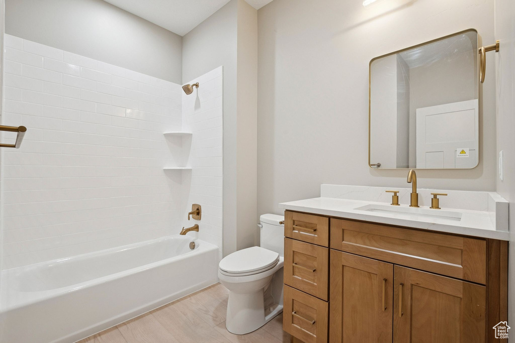 Bathroom with toilet, vanity, and  shower combination