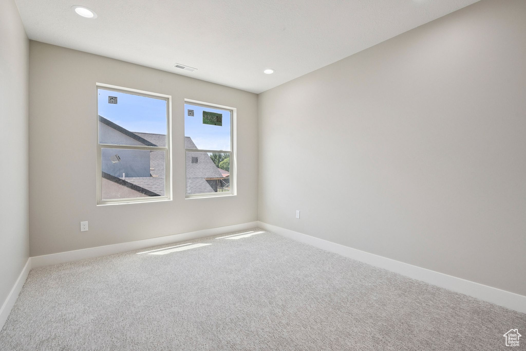 Empty room with carpet floors, baseboards, and recessed lighting