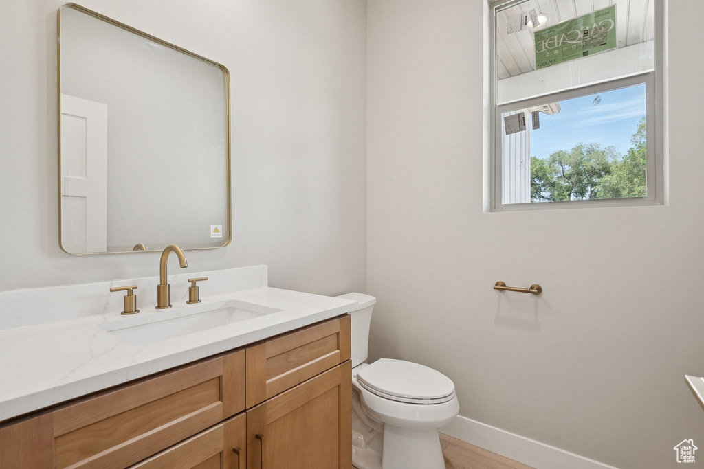 Bathroom with vanity, toilet, and baseboards