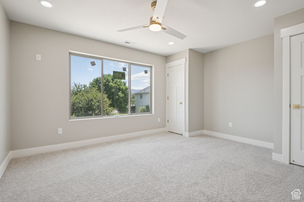 Unfurnished bedroom with recessed lighting, light colored carpet, baseboards, and a ceiling fan