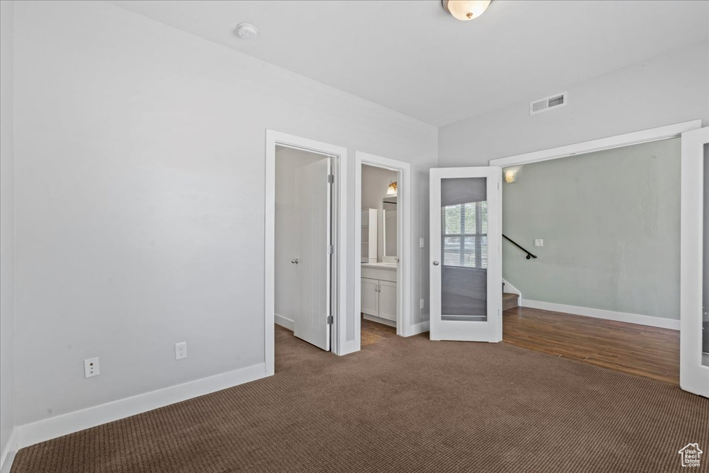 Unfurnished bedroom with baseboards, carpet, and connected bathroom