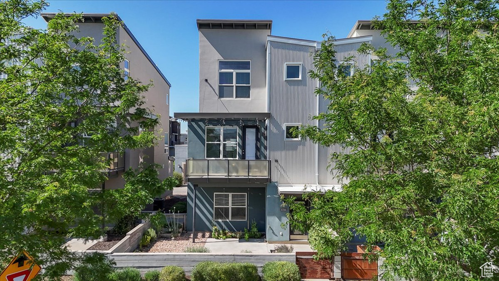 Back of property featuring a garden and stucco siding