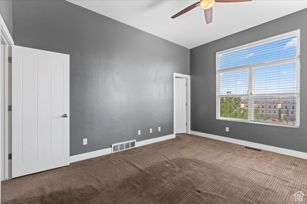 Spare room featuring ceiling fan, carpet flooring, and baseboards
