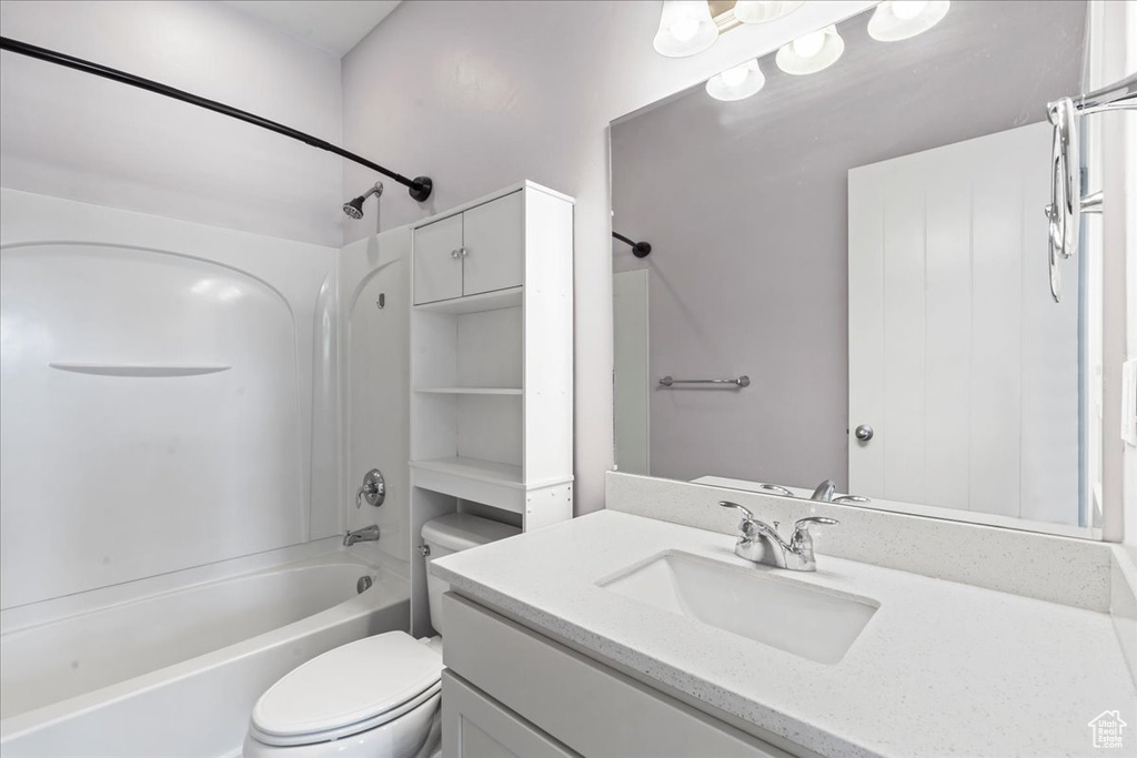 Bathroom featuring toilet, bathtub / shower combination, and vanity