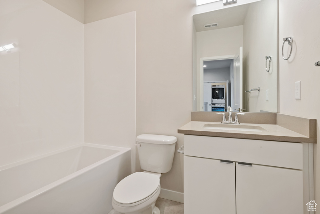 Full bathroom featuring toilet, vanity, baseboards,  shower combination, and tile patterned flooring