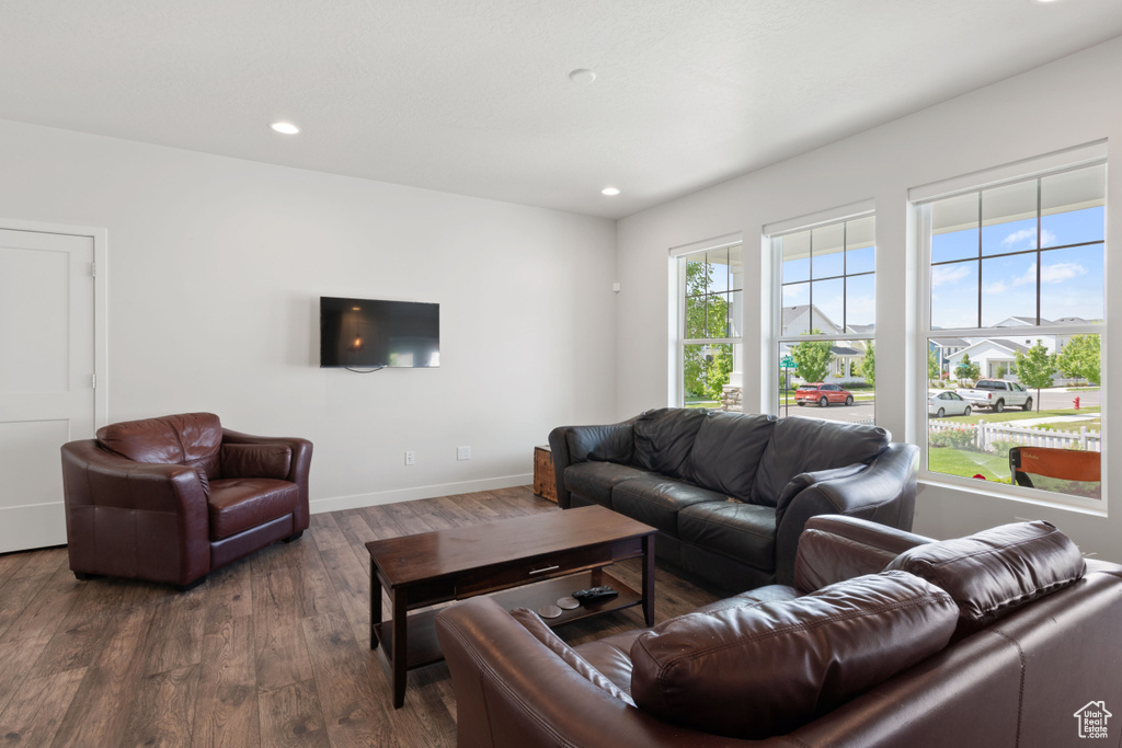 Living room with wood finished floors, baseboards, and recessed lighting