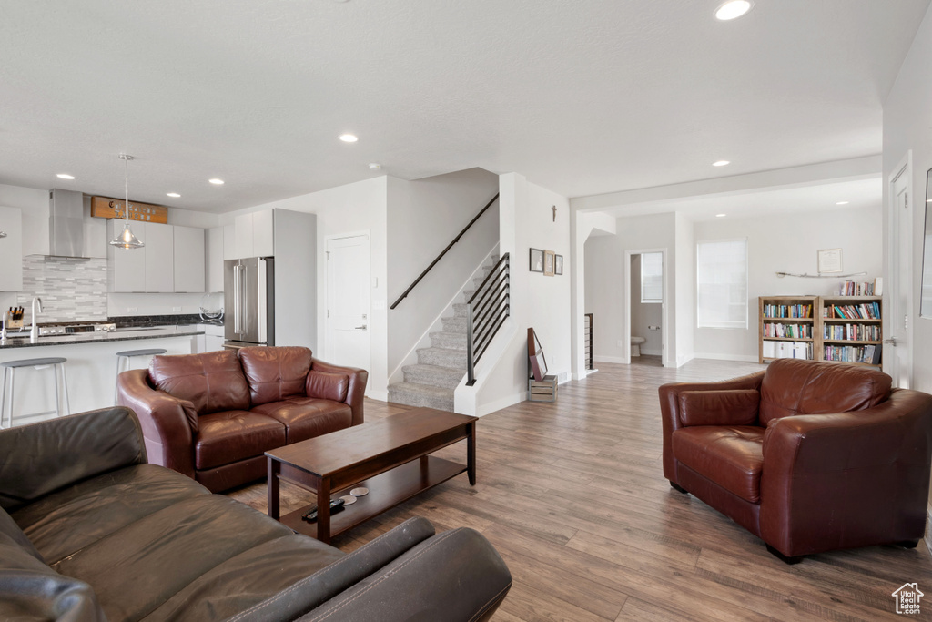 Living area featuring stairs, recessed lighting, wood finished floors, and baseboards