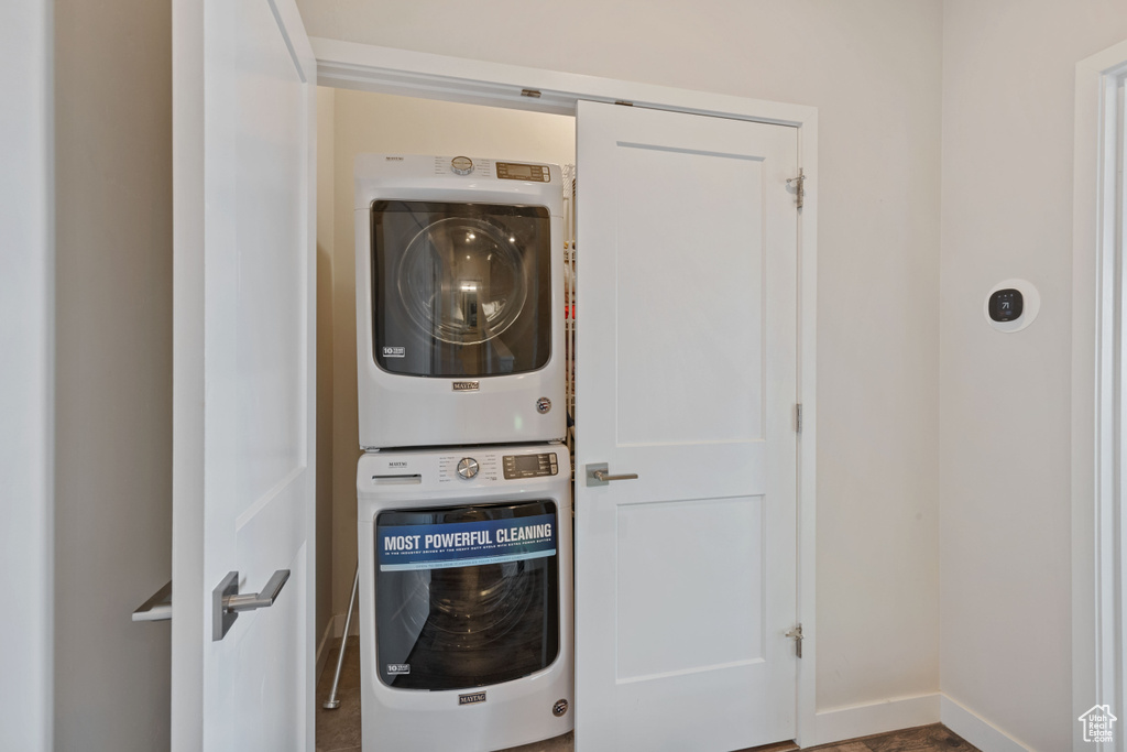 Laundry area featuring stacked washer / drying machine and baseboards