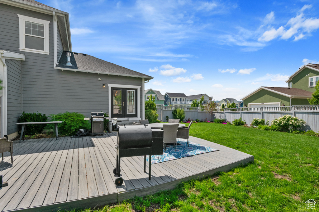 Wooden terrace featuring grilling area, a residential view, and outdoor dining space
