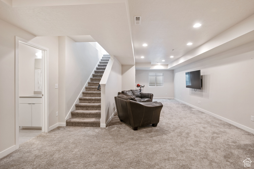 Carpeted living room with recessed lighting, stairway, and baseboards