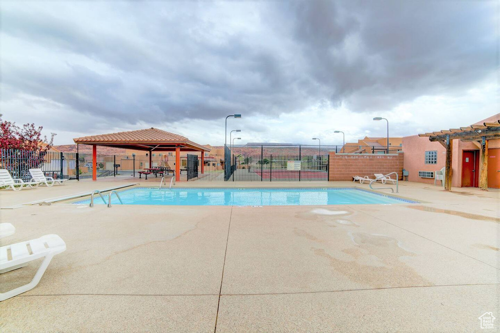 Community pool with a patio area and a gazebo