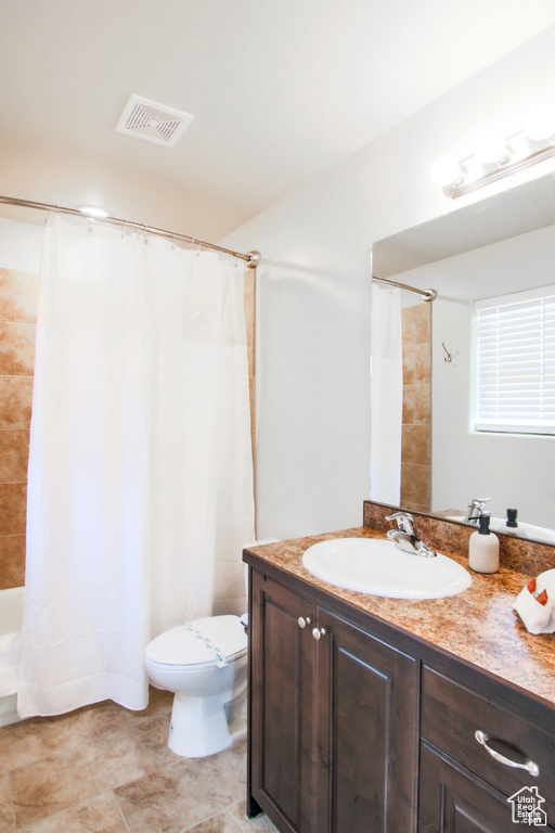 Full bathroom featuring vanity, toilet, and shower / bathtub combination with curtain