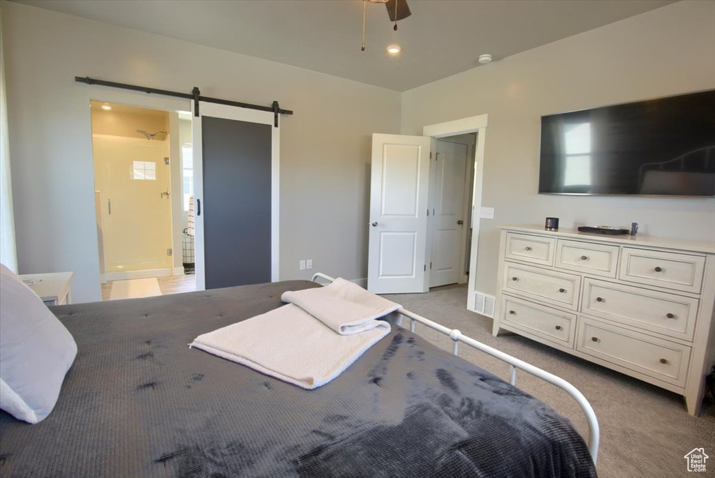 Bedroom featuring a barn door and light carpet