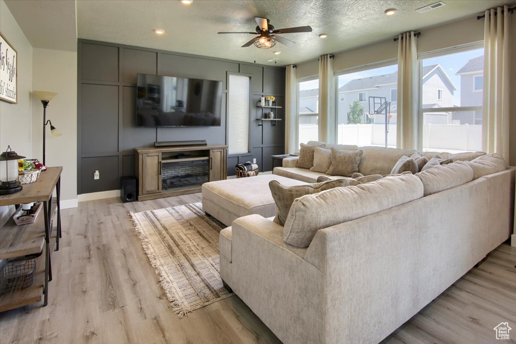 Living room with ceiling fan, light wood finished floors, recessed lighting, and baseboards