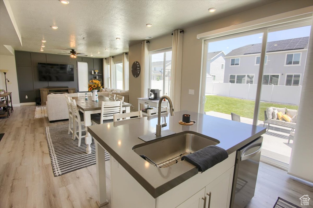 Kitchen featuring a sink, light wood finished floors, dishwasher, ceiling fan, and recessed lighting