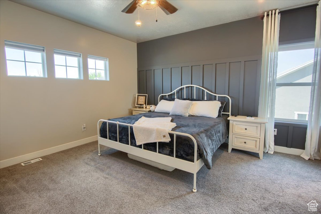 Bedroom featuring light colored carpet, baseboards, and ceiling fan
