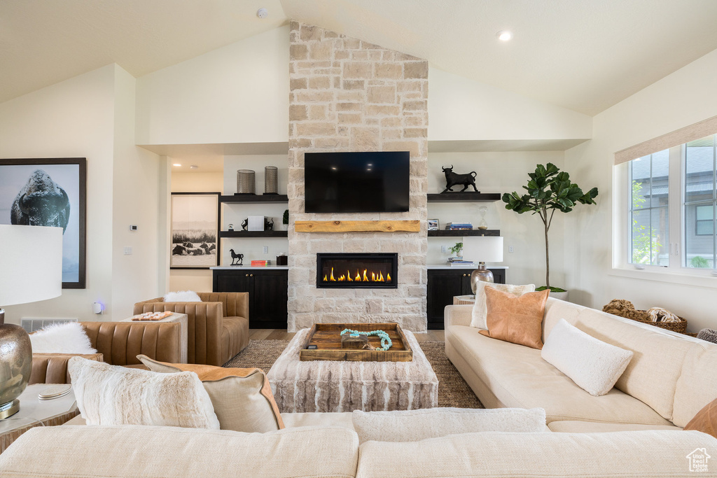 Living area with high vaulted ceiling and a stone fireplace