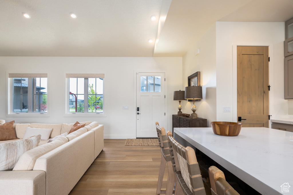 Living room featuring light wood-style floors, baseboards, and recessed lighting