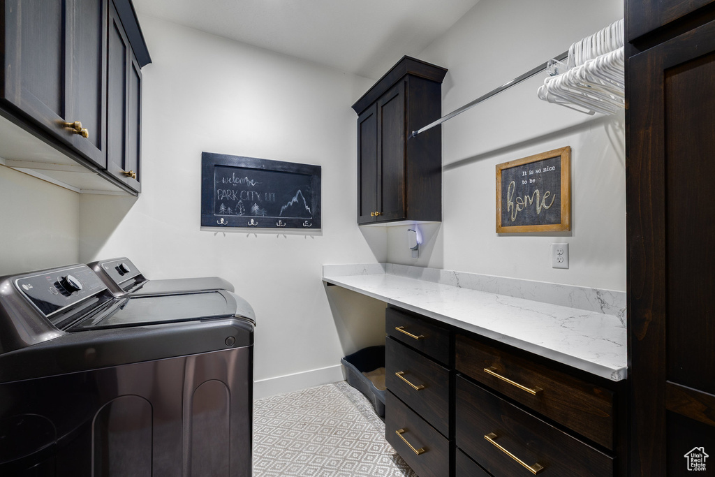 Laundry room with separate washer and dryer, cabinet space, and baseboards