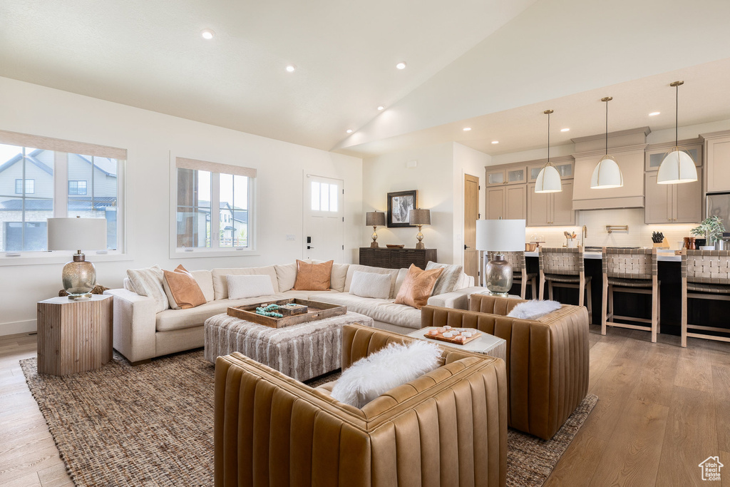 Living room with wood finished floors, recessed lighting, and high vaulted ceiling