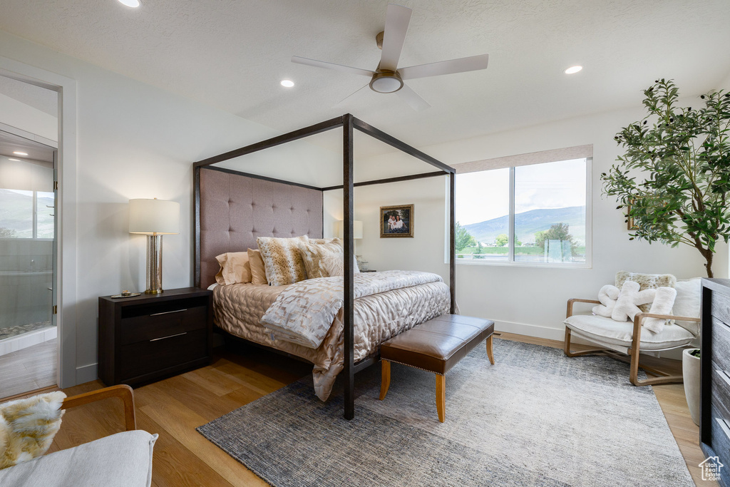 Bedroom with light wood-style floors, recessed lighting, a ceiling fan, baseboards, and connected bathroom
