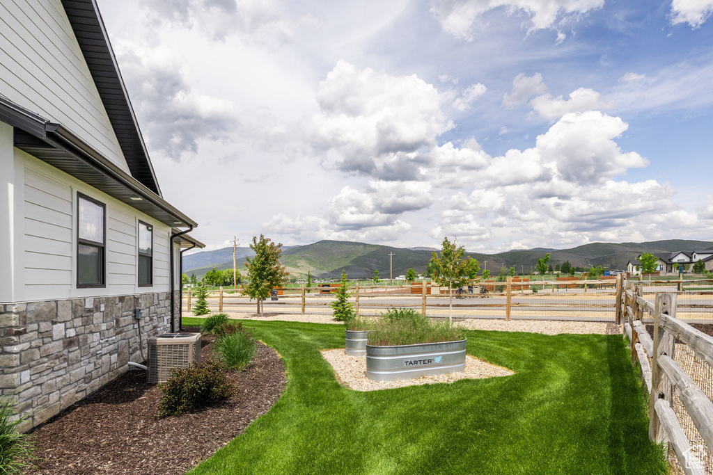 View of yard with a mountain view, central AC, and a view of rural / pastoral area