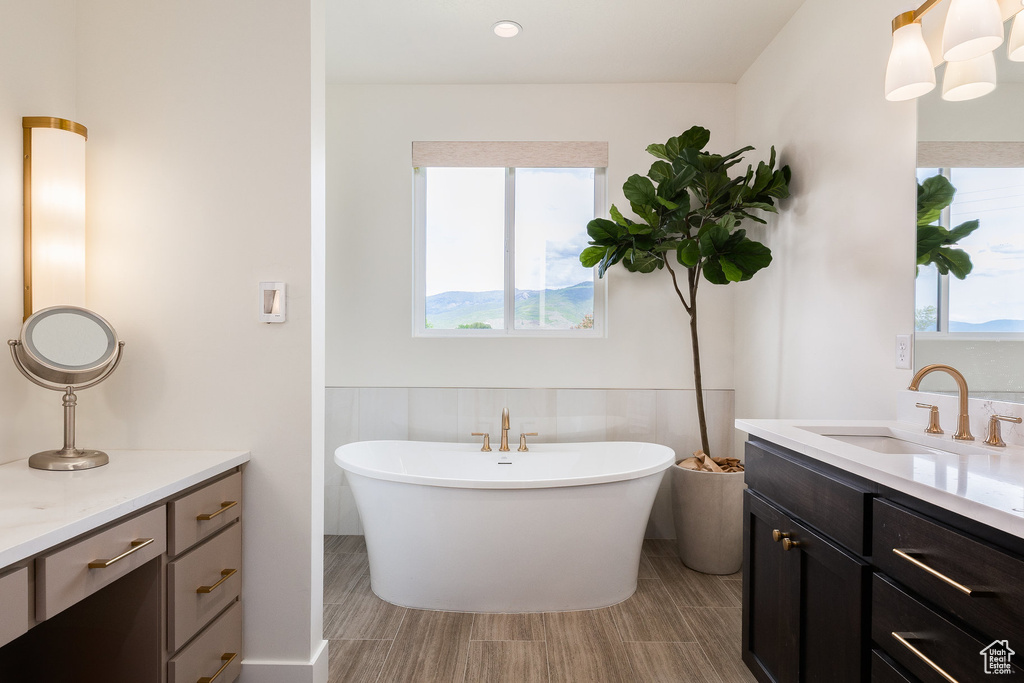 Bathroom with vanity, plenty of natural light, and a soaking tub