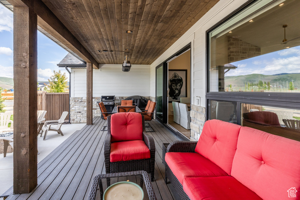 Wooden deck featuring grilling area, a mountain view, and outdoor dining area
