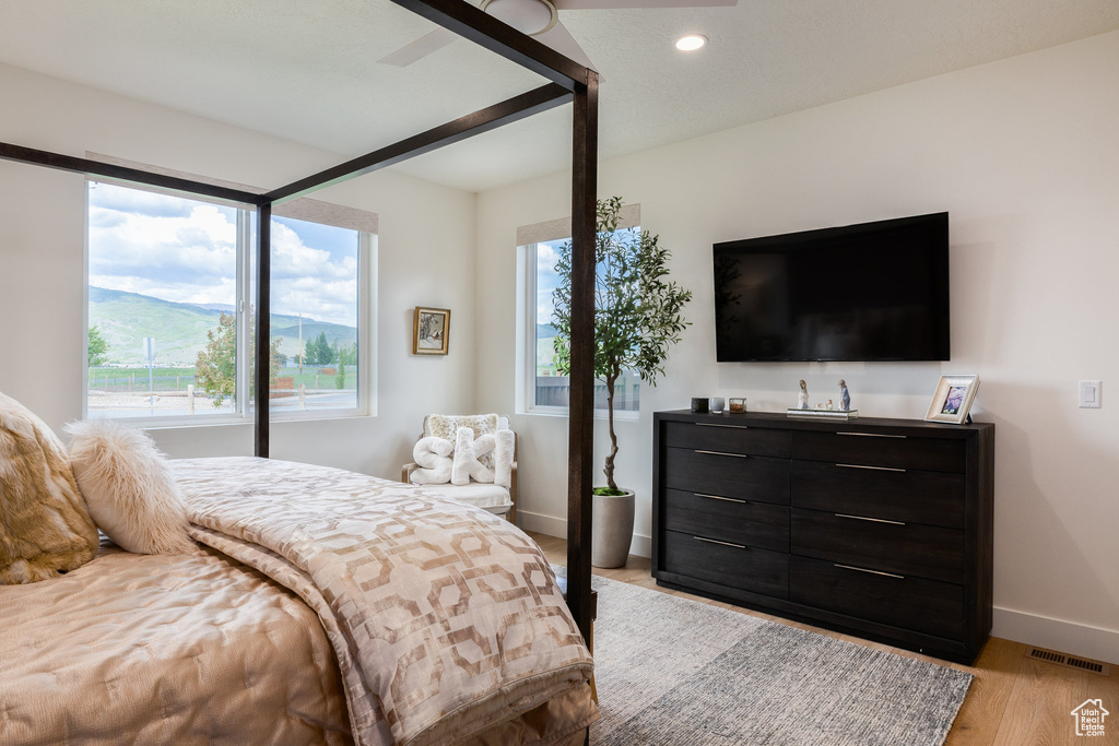 Bedroom featuring baseboards, multiple windows, recessed lighting, and light wood-style flooring