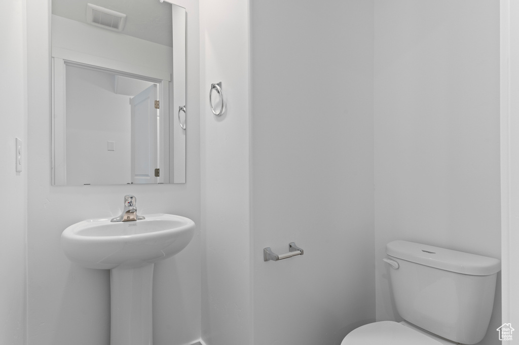 Half bathroom featuring toilet and a sink