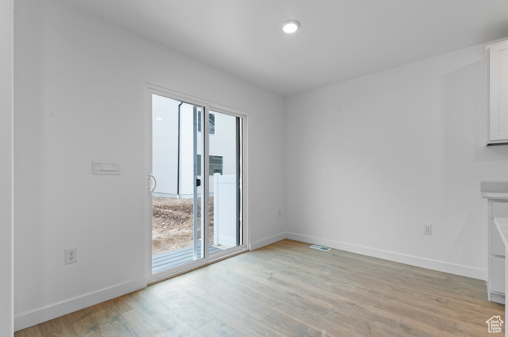 Unfurnished room with light wood-style flooring, baseboards, and recessed lighting
