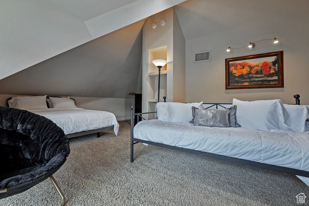 Carpeted bedroom featuring vaulted ceiling