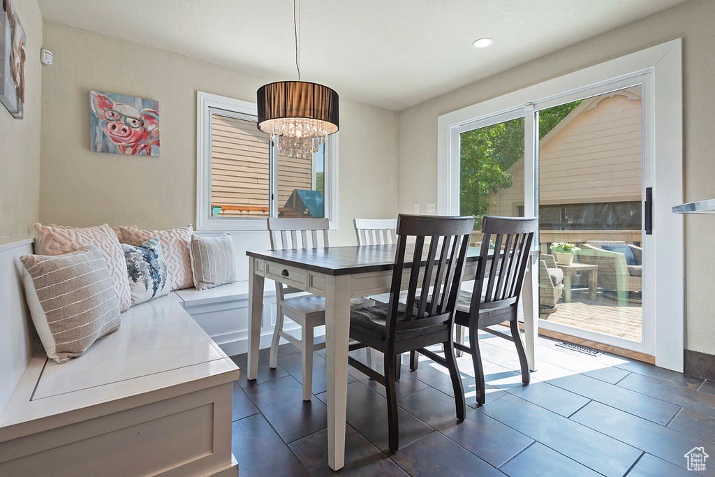 Dining space featuring recessed lighting, dark tile patterned floors, and a chandelier