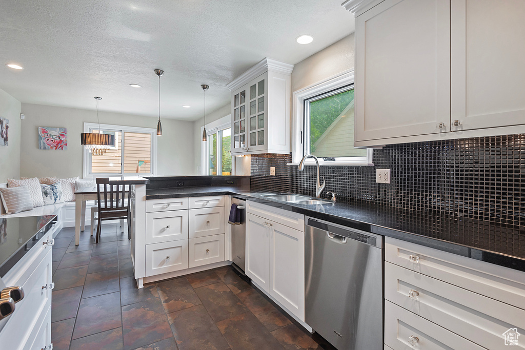 Kitchen with stainless steel dishwasher, a sink, dark countertops, a peninsula, and recessed lighting
