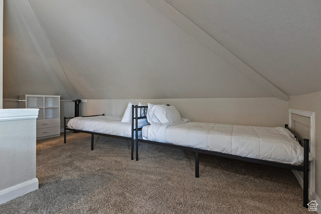 Carpeted bedroom featuring vaulted ceiling