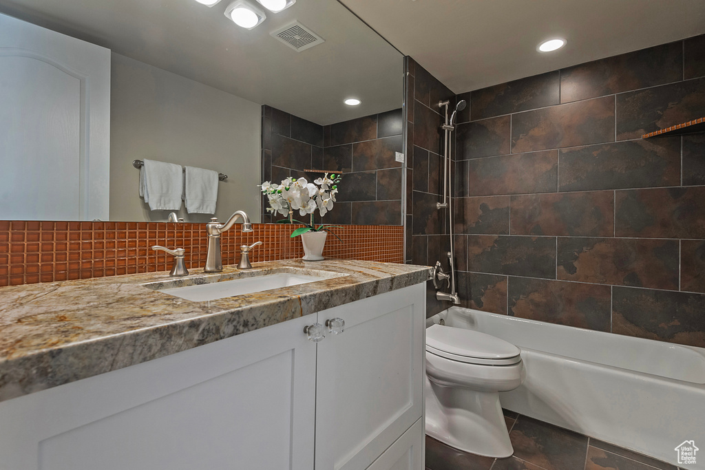 Full bath featuring vanity, shower / bath combination, toilet, recessed lighting, and tasteful backsplash