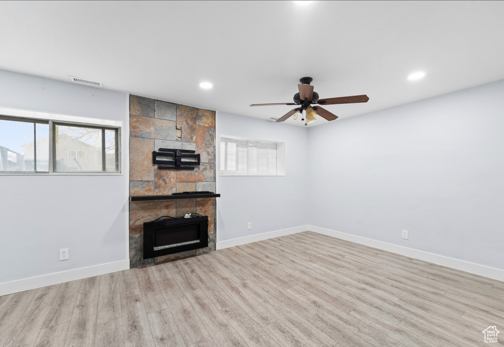 Unfurnished living room with a fireplace, ceiling fan, wood finished floors, recessed lighting, and baseboards
