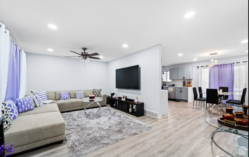 Living area featuring a ceiling fan, light wood finished floors, recessed lighting, and baseboards
